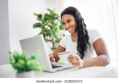 A Young African American Businesswoman Working At Laptop At Home Office With Credit Card On Hand