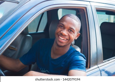 Young African- American cab/ taxi driver looking at the camera smiling 