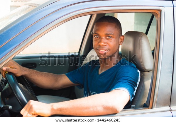 Young African- American cab/ taxi driver looking at the\
camera smiling 