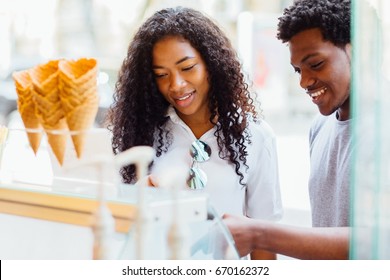 Young African American Couple Choosing Ice Cream In The Pastry Shop.