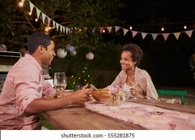 Young African American Couple At A Dinner Table In Garden