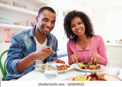 Young African American Couple Eating Meal At Home