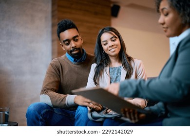 Young African American couple having a meeting with their financial advisor in the office. - Powered by Shutterstock