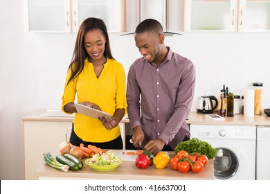 Young African American Couple In Home Kitchen Using Electronic Tablet - Powered by Shutterstock