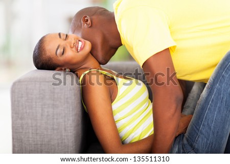 young african american couple kissing on the sofa