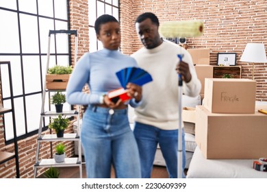 Young african american couple moving to a new home choosing walls color skeptic and nervous, frowning upset because of problem. negative person.  - Shutterstock ID 2230609399