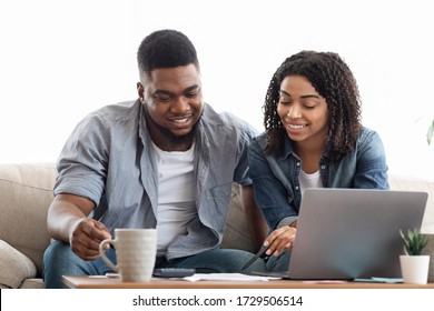 Young African American Couple Planning Budget Together At Home, Writing Notes To Notebook, Creating Checklist For Shopping Or Guest List For Wedding