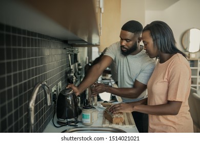 Young African American Couple Standing Together At Their Kitchen Counter In The Morning Making Breakfast And Fresh Coffee