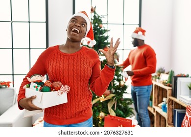 Young African American Couple Standing By Christmas Tree Crazy And Mad Shouting And Yelling With Aggressive Expression And Arms Raised. Frustration Concept. 