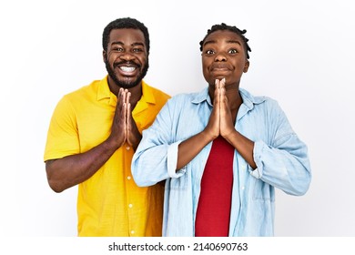 Young African American Couple Wearing Casual Clothes Praying With Hands Together Asking For Forgiveness Smiling Confident. 