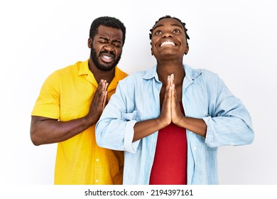 Young African American Couple Wearing Casual Clothes Begging And Praying With Hands Together With Hope Expression On Face Very Emotional And Worried. Begging. 