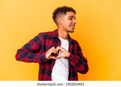 Young african american curly man isolated on purple smiling and showing a heart shape with hands. - Shutterstock ID 1902024961
