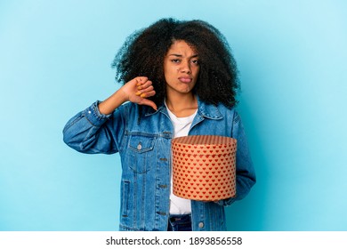 Young African American Curly Woman Holding A Valentines Day Gift Showing A Dislike Gesture, Thumbs Down. Disagreement Concept.