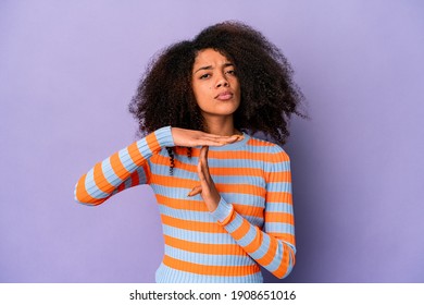 Young african american curly woman isolated on purple background showing a timeout gesture.