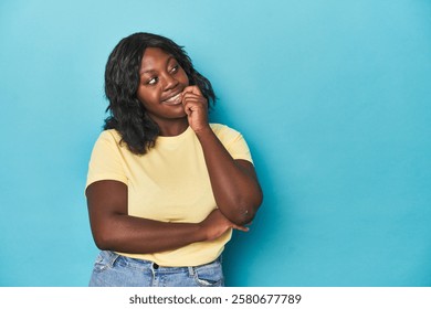 Young african american curvy woman relaxed thinking about something looking at a copy space.