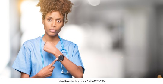 Young African American Doctor Woman Over Isolated Background In Hurry Pointing To Watch Time, Impatience, Upset And Angry For Deadline Delay