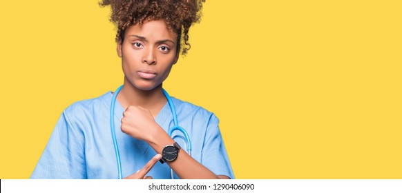 Young African American Doctor Woman Over Isolated Background In Hurry Pointing To Watch Time, Impatience, Upset And Angry For Deadline Delay