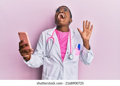 Young african american doctor woman doing video call using smartphone angry and mad screaming frustrated and furious, shouting with anger looking up.  - Powered by Shutterstock