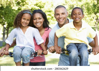 Young African American Family Cycling In Park