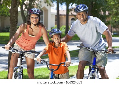 A Young African American Family, Woman, Man, Father, Mother & Boy Child Riding Bicycles In The Summer