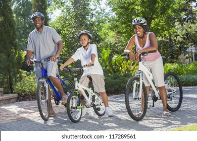 A Young African American Family, Woman, Man, Father, Mother & Boy Child Riding Bicycles In The Summer