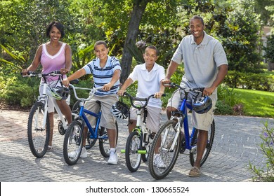 A Young African American Family, Woman, Man, Father, Mother & Two Sons  Boy Children Riding Bicycles In The Summer