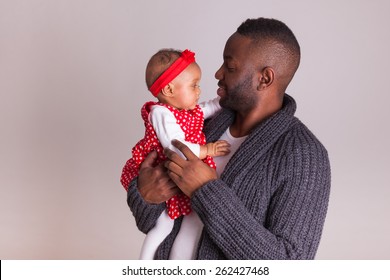 Young African American Father Holding With Her Baby Girl