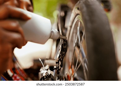 Young african american female cyclist diligently cleaning and greasing her bike pedal for optimal performance. Close up woman doing bicycle maintenance ensuring top-notch service and smooth ride. - Powered by Shutterstock