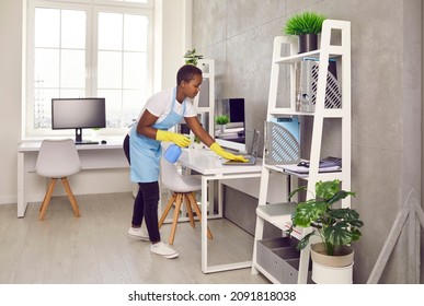 Young African American Female Housekeeper Clean Office Surfaces With Detergent. Black Woman Maid Janitor Take Care Of Workplace Hygiene, Cleanse Dirt Dust. Good Housekeeping Service Concept.