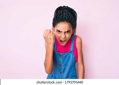 Young African American Girl Child With Braids Wearing Casual Clothes Over Pink Background Angry And Mad Raising Fist Frustrated And Furious While Shouting With Anger. Rage And Aggressive Concept. 