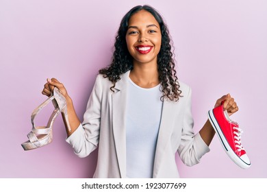 Young African American Girl Choosing High Heel Shoes And Sneakers Smiling With A Happy And Cool Smile On Face. Showing Teeth. 