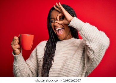 Young African American Girl Drinking A Coffee Cup Over Red Isolated Background With Happy Face Smiling Doing Ok Sign With Hand On Eye Looking Through Fingers