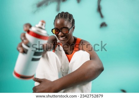 Young African American girl ethnicity hold in hand container with spray paint for graffiti 