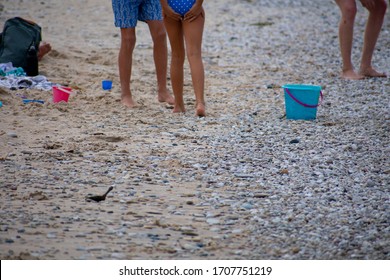 Young African American Girl With Family Having Fun On Lake Michigan Beachfront From Hips Down. Family Vacation At Sleeping Bear Dunes National Lakeshore On Great Summer Day. Toys Also Along The Beach.