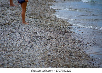 Young African American Girl With Family Having Fun On Lake Michigan Beachfront From Hips Down. Family Vacation At Sleeping Bear Dunes National Lakeshore On Great Summer Day. Toys Also Along The Beach.