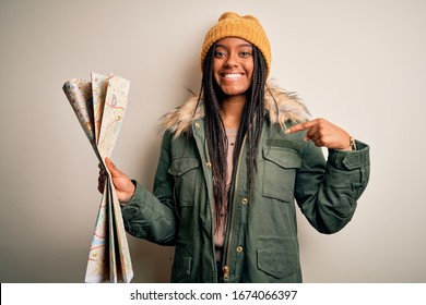 Young African American Girl Going On Vacation Holding Turist City Map Over Isolated Background With Surprise Face Pointing Finger To Himself