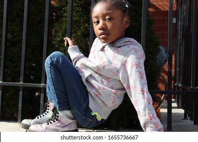 Young African American Girl Outside Apartment Building In City.