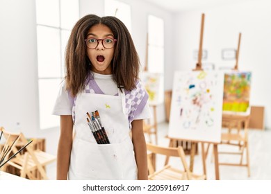 Young African American Girl Painting At Art Studio Scared And Amazed With Open Mouth For Surprise, Disbelief Face 