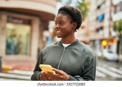 Young african american girl smiling happy using smartphone at the city - Shutterstock ID 1927722083