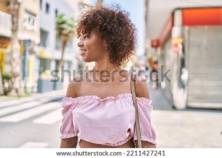 Young african american girl smiling happy standing at the city.