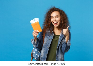 Young African American Girl Teen Student In Denim Clothes, Backpack Hold Pass Isolated On Blue Wall Background Studio Portrait. Education In High School University College Concept. Mock Up Copy Space