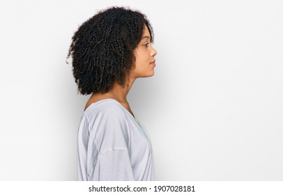 Young african american girl wearing casual clothes looking to side, relax profile pose with natural face with confident smile. 