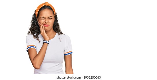 Young african american girl wearing casual clothes touching mouth with hand with painful expression because of toothache or dental illness on teeth. dentist 
