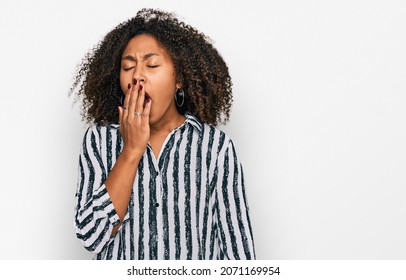Young african american girl wearing casual clothes bored yawning tired covering mouth with hand. restless and sleepiness. 