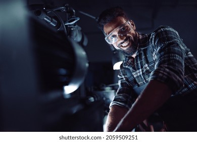 Young African American Industrial Man During Night Shift Indoors In Metal Workshop,looking At Camera