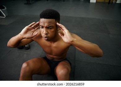 Young African American Male Doing Sit-ups On The Floor In The Gym. Mixed Race Male Personal Trainer Exercising Shirtless Indoors. High Quality Photo