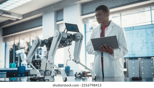 Young African American Male Engineer Testing Industrial Programmable Robot Animal in a Factory Development Workshop. Black Researcher in a Lab Coat Developing AI Canine Prototype, Using Laptop - Powered by Shutterstock