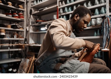 Young African American male owner of shoemaking workshop - Powered by Shutterstock