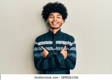 Young african american man with afro hair wearing casual clothes happy face smiling with crossed arms looking at the camera. positive person. 