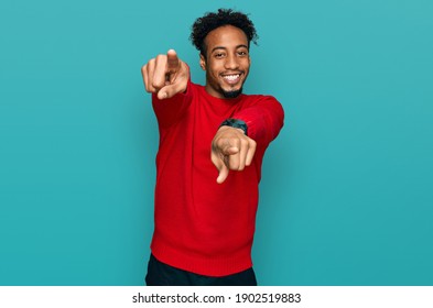 Young african american man with beard wearing casual winter sweater pointing to you and the camera with fingers, smiling positive and cheerful 